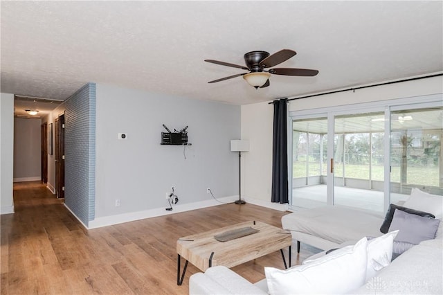 living room featuring ceiling fan, a textured ceiling, and hardwood / wood-style flooring