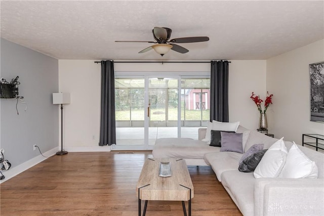 living room with ceiling fan, hardwood / wood-style floors, and a textured ceiling