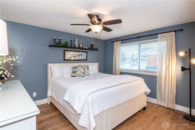 bedroom with light hardwood / wood-style floors and ceiling fan