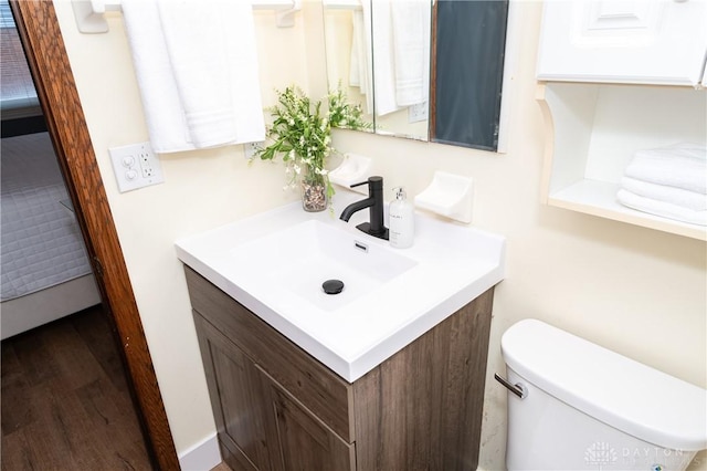 bathroom with vanity, wood-type flooring, and toilet