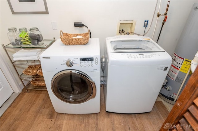 washroom with washer and dryer, gas water heater, and light hardwood / wood-style floors