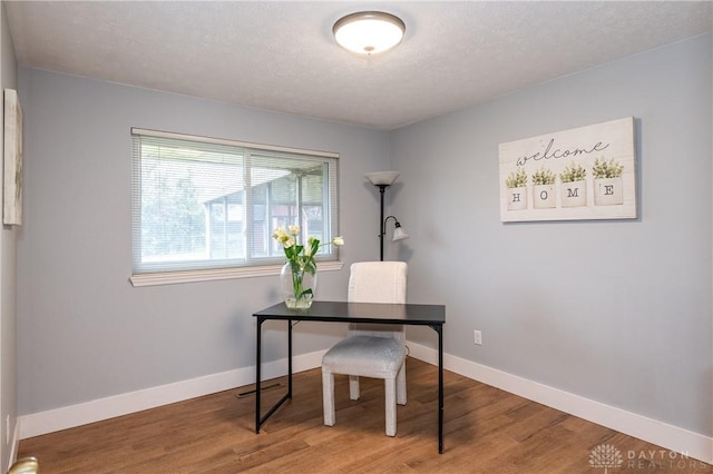 office area with hardwood / wood-style floors and a textured ceiling