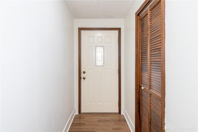 doorway featuring a textured ceiling and light hardwood / wood-style flooring