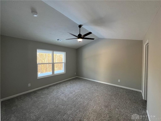 carpeted empty room featuring ceiling fan, lofted ceiling, and a textured ceiling