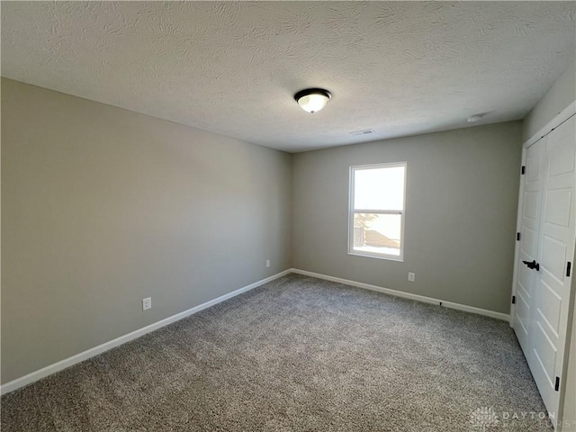 carpeted spare room with a textured ceiling