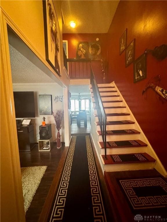 staircase featuring a textured ceiling