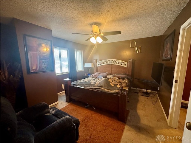 bedroom with a textured ceiling, light colored carpet, and ceiling fan