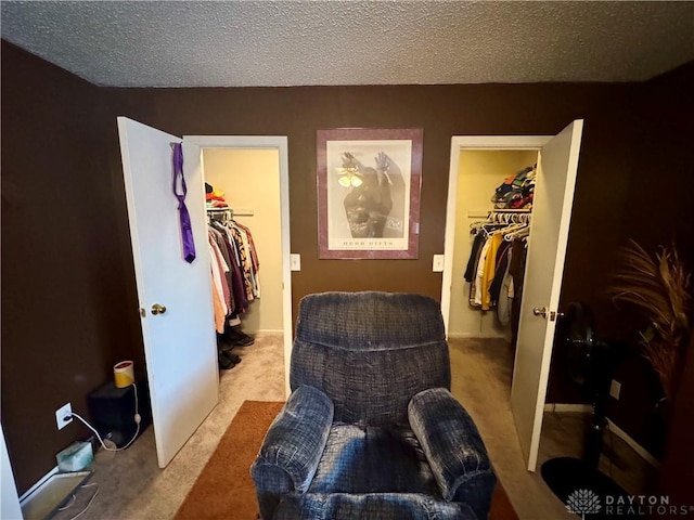 interior space with a walk in closet, a closet, and a textured ceiling