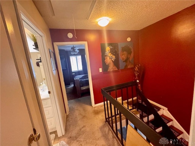 hallway featuring carpet and a textured ceiling