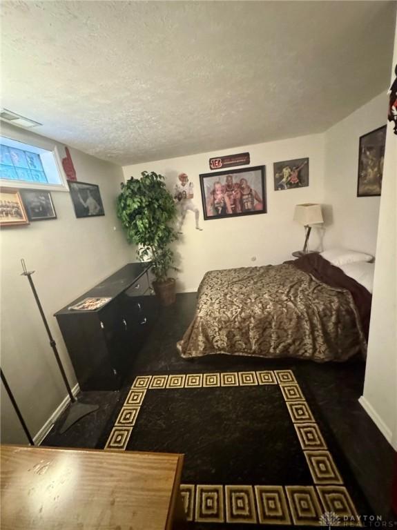 bedroom featuring a textured ceiling and dark wood-type flooring