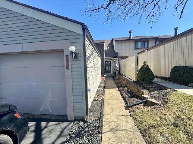 view of side of property with a garage and fence