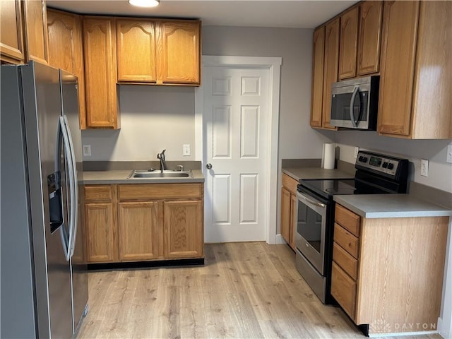 kitchen with light hardwood / wood-style floors, sink, and appliances with stainless steel finishes