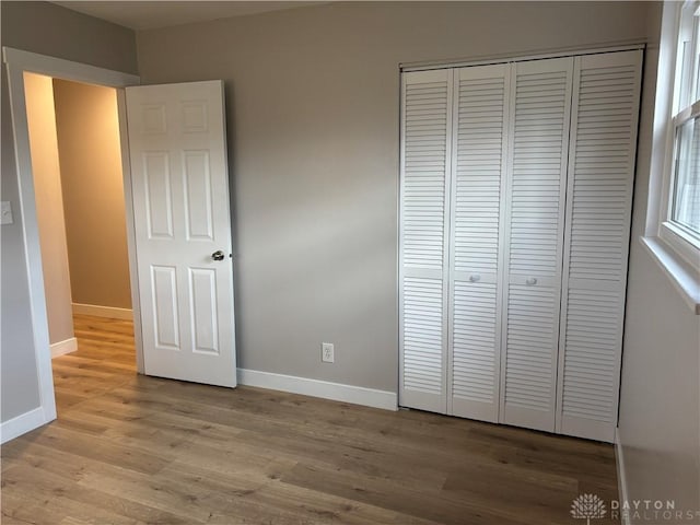 unfurnished bedroom featuring light wood-type flooring and a closet