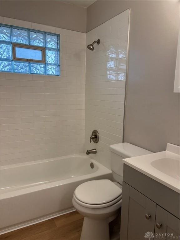 full bathroom featuring wood-type flooring, vanity, toilet, and tiled shower / bath