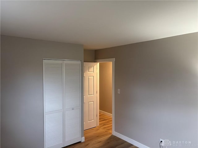 unfurnished bedroom with a closet and light hardwood / wood-style flooring