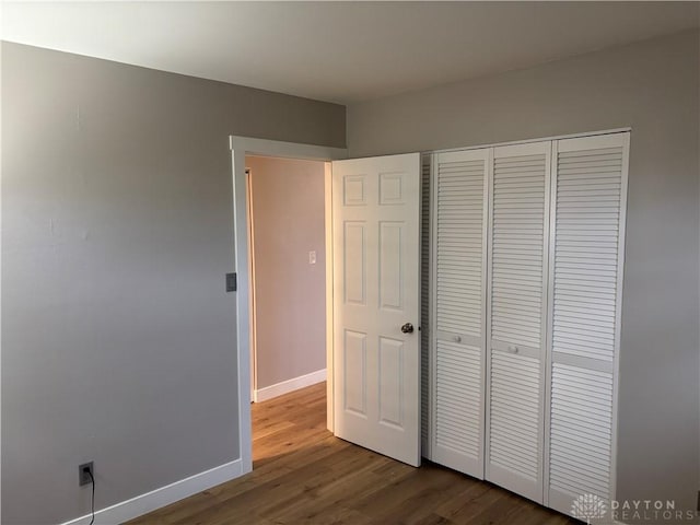 unfurnished bedroom featuring a closet and hardwood / wood-style flooring