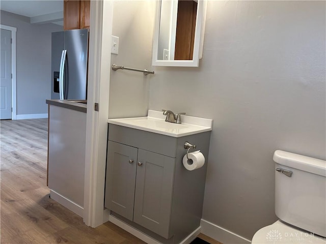 bathroom with hardwood / wood-style flooring, vanity, and toilet