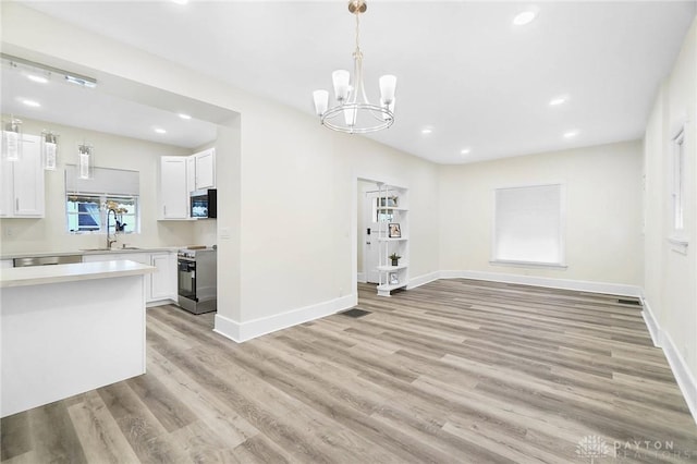 dining space with sink, a chandelier, and light hardwood / wood-style flooring