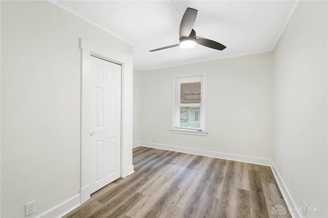 unfurnished bedroom with a closet, light hardwood / wood-style flooring, ceiling fan, and ornamental molding