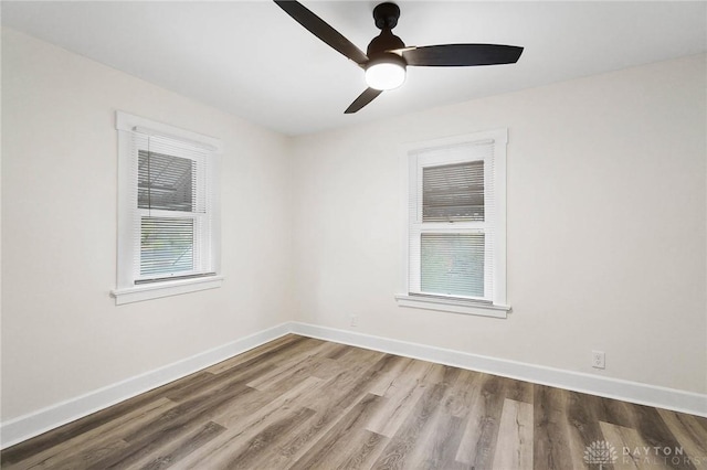 empty room with hardwood / wood-style flooring, ceiling fan, and a healthy amount of sunlight