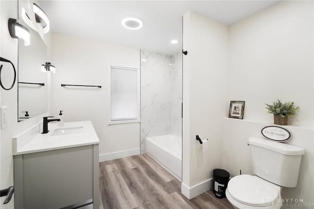 full bathroom with tiled shower / bath, hardwood / wood-style floors, vanity, and toilet