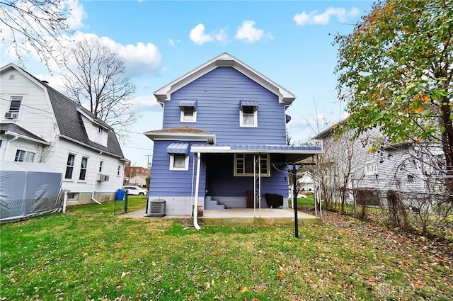 rear view of property with a lawn, a patio area, and central AC