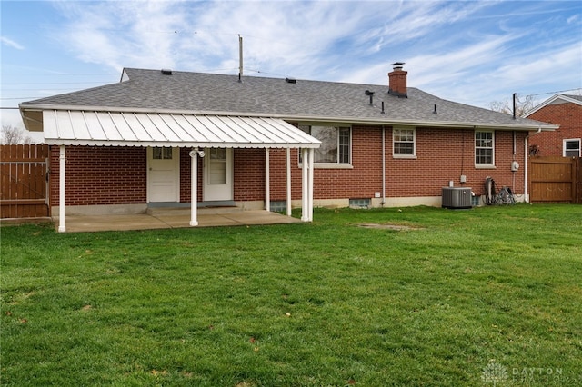 back of house with a patio, a yard, and central air condition unit