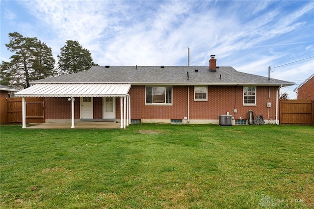 back of house featuring a yard, central AC, and a patio area