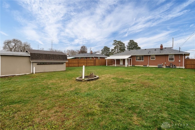 view of yard featuring central AC unit and a shed