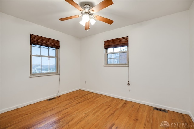 unfurnished room featuring plenty of natural light, ceiling fan, and light wood-type flooring