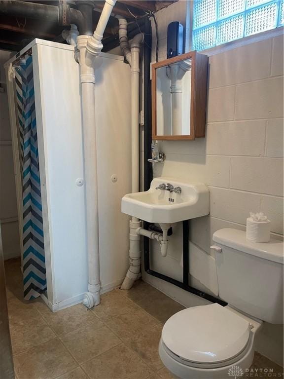 bathroom with a shower with curtain, toilet, and tile patterned flooring