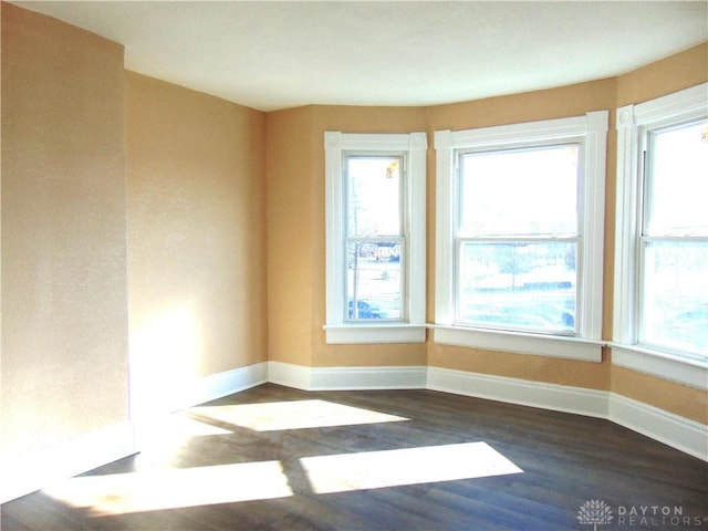 empty room with dark hardwood / wood-style flooring