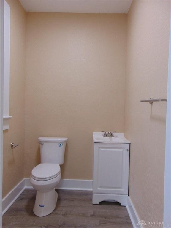 bathroom featuring wood-type flooring, toilet, and vanity