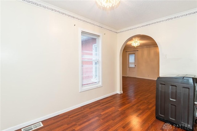 spare room featuring dark hardwood / wood-style floors and ornamental molding