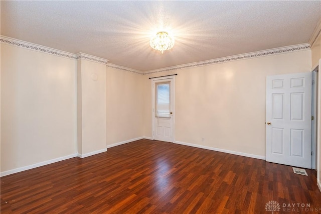 spare room featuring dark hardwood / wood-style floors, crown molding, and a textured ceiling