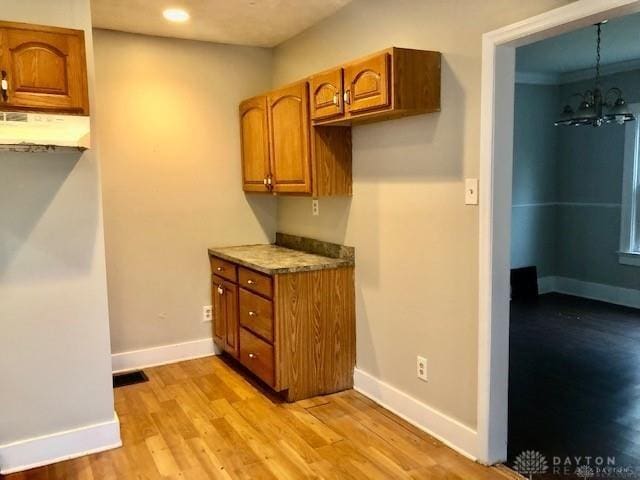 kitchen featuring a chandelier, pendant lighting, and light hardwood / wood-style floors