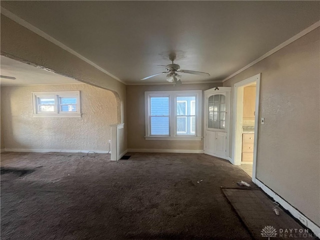 interior space with ceiling fan, ornamental molding, and carpet