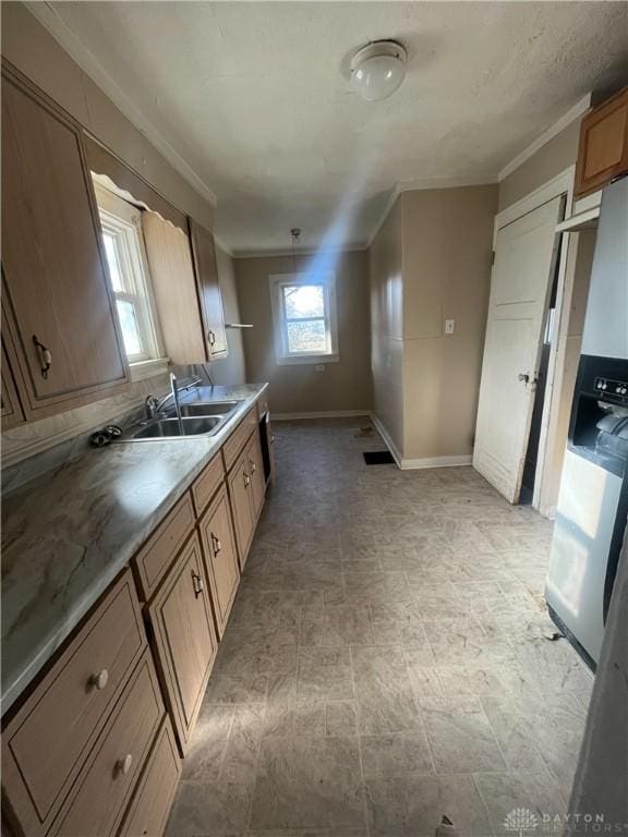 kitchen featuring crown molding, sink, and stainless steel refrigerator with ice dispenser