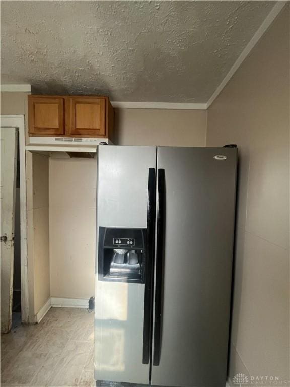 kitchen featuring ornamental molding, stainless steel fridge, and a textured ceiling