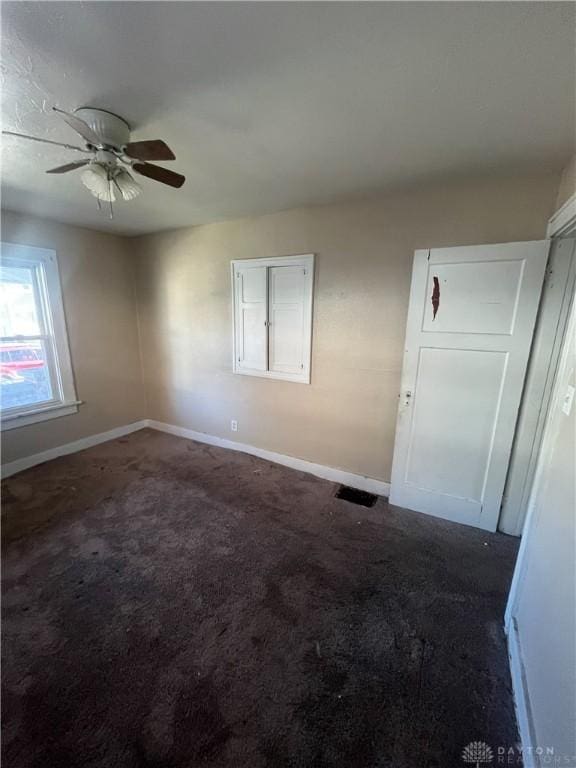 carpeted spare room with ceiling fan