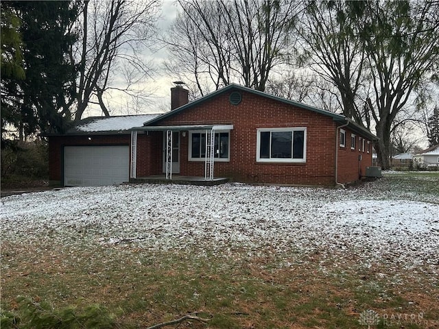 single story home featuring cooling unit and a garage