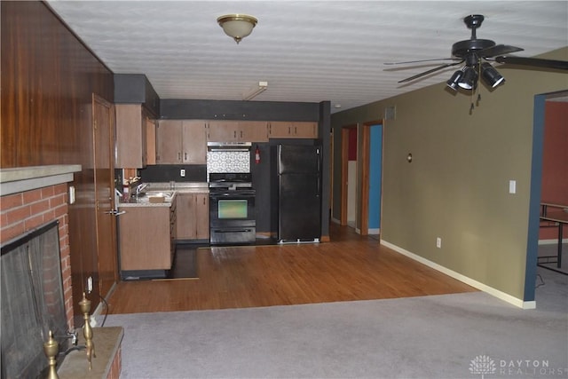 kitchen with ceiling fan, backsplash, wood-type flooring, a fireplace, and black appliances