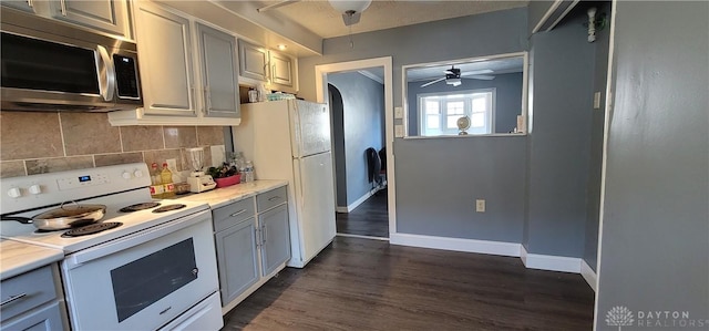 kitchen featuring gray cabinetry, ceiling fan, tasteful backsplash, dark hardwood / wood-style flooring, and white appliances