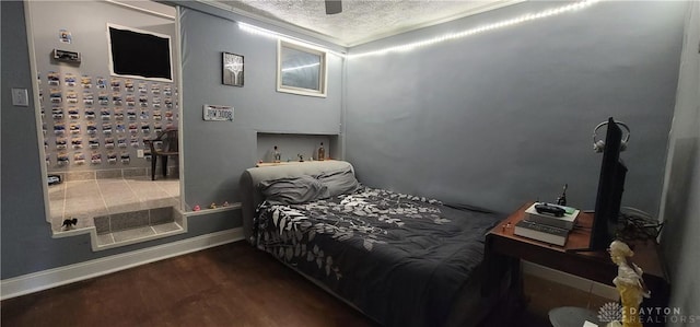 bedroom with ceiling fan, dark wood-type flooring, and a textured ceiling