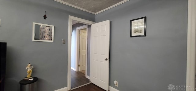 hall featuring a textured ceiling, dark hardwood / wood-style floors, and ornamental molding