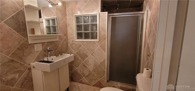 bathroom with a shower with shower door, tile walls, and toilet