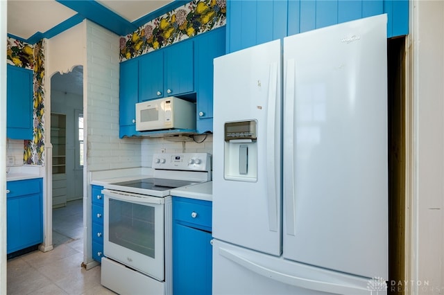 kitchen with backsplash, light tile patterned floors, white appliances, and blue cabinets