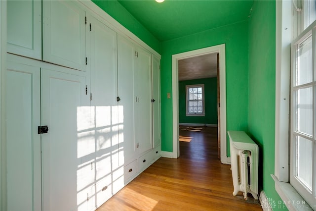 corridor featuring light hardwood / wood-style floors and radiator heating unit