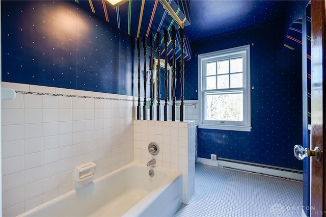 bathroom featuring tile patterned floors, a washtub, tile walls, and a baseboard heating unit