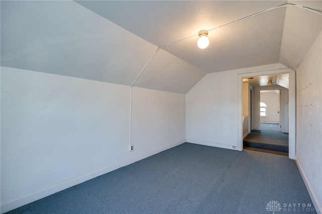 additional living space featuring carpet and lofted ceiling